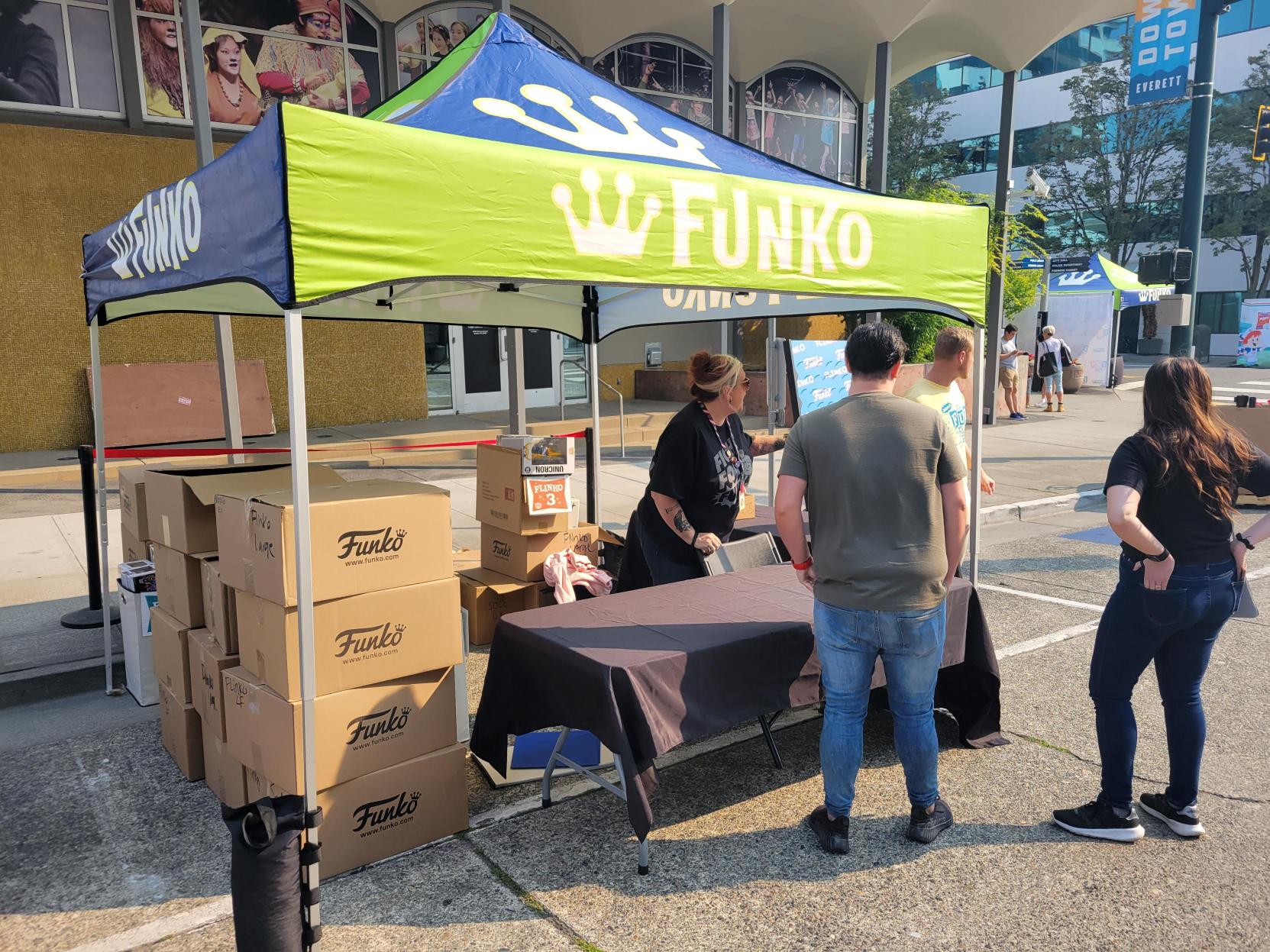Set-Up: Volunteers help set up a tent on the street. Funko boxes are packed below.